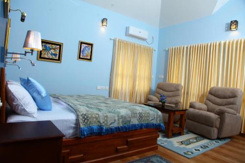a bedroom with a bed and a desk and a chair at Zenha Resorts in Munnar