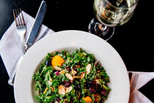 a bowl of salad on a table with a glass of wine at Colgate Inn in Hamilton