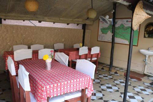 uma sala de jantar com uma mesa e cadeiras e um lavatório em Peacock - a family-run hotel em Sauraha