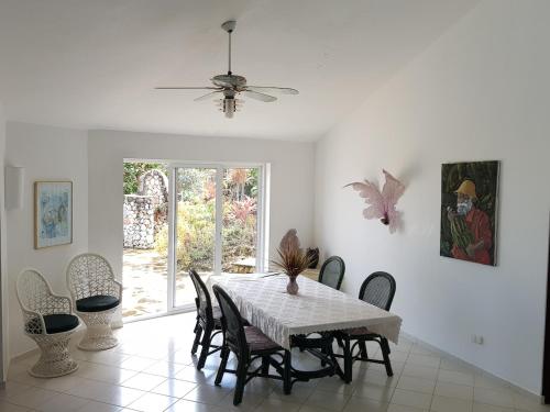 a dining room with a table and chairs and a ceiling fan at Casa Caracol Los Farallones in Cabrera