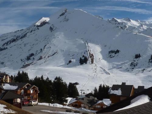 a snow covered mountain with a village and a ski slope at MONT BLANC Soleil C19 in Manigod