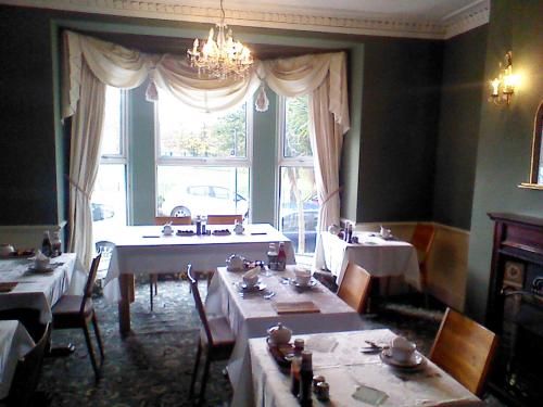 a dining room with tables and a large window at Mountbatten Hotel in Plymouth
