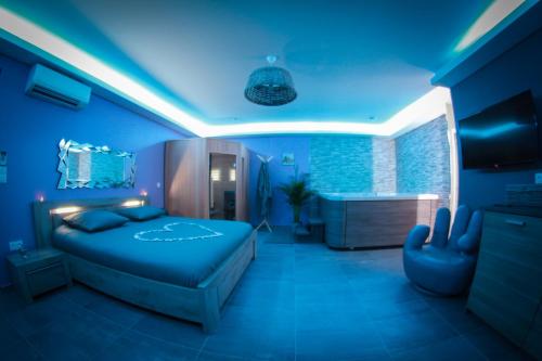 Dormitorio azul con cama y bañera en Nuit vip spa sauna privatif, en Le Rove
