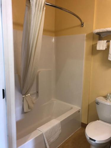 a bathroom with a white tub and a toilet at Budget Inn Williamsport in Williamsport