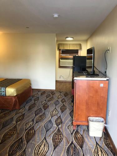 a small hotel room with a bed and a desk at Budget Inn Williamsport in Williamsport