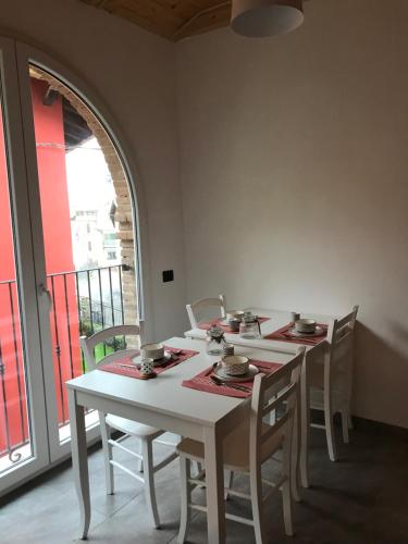 una mesa con sillas, una mesa blanca y una ventana en Il fienile b&b, en Stazzano
