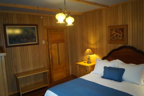 a bedroom with a bed with a blue pillow at Tradicion Austral Bed & Breakfast in Puerto Varas