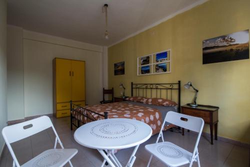 1 dormitorio con 1 cama, mesa y sillas en B&B la Bitta, en Cagliari