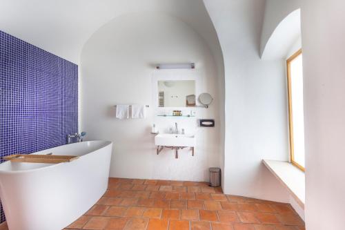 a bathroom with a white tub and a sink at Hotel At the Green Grape in Prague