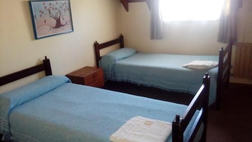 Habitación de hotel con 2 camas y ventana en Hosteria Wikter en San Carlos de Bariloche