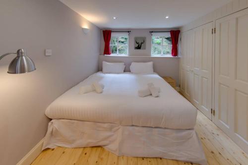 Cette chambre comprend un grand lit blanc et des rideaux rouges. dans l'établissement ALTIDO Warm and Welcoming flat near Edinburgh Castle, à Édimbourg