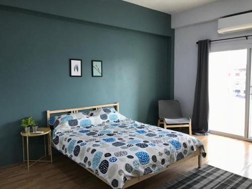 um quarto com uma cama com uma parede azul em Hug House em Chiang Rai