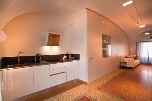 a kitchen with white cabinets and a counter top at Anfite Luxury Apartment Affresco San Silvestro in Verona