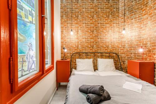 ブダペストにあるThe red - industrial studio in the center of Budapestのレンガの壁のドミトリールームのベッド1台分です。