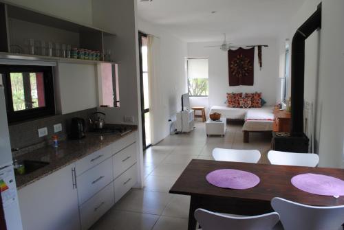 a kitchen and living room with a table and chairs at Casas del Champaquí in San Javier