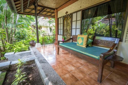 a porch of a house with a bench at Hotel Pondok Sari Beach & SPA Resort in Pemuteran