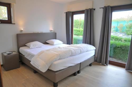 a bedroom with a bed and a large window at Vue de Rome in Durbuy