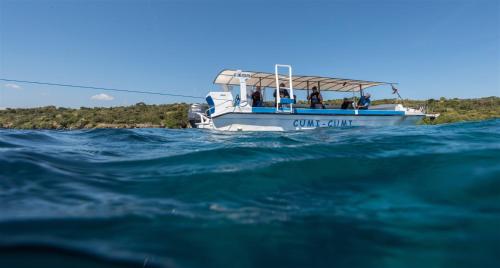 a group of people riding a boat in the ocean at Hotel Pondok Sari Beach & SPA Resort in Pemuteran