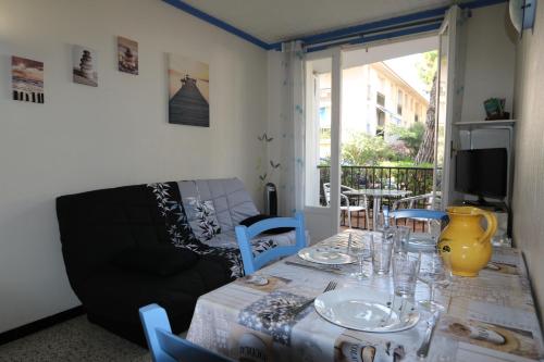 - une table à manger avec des chaises et un canapé dans l'établissement La palmeraie, à Argelès-sur-Mer