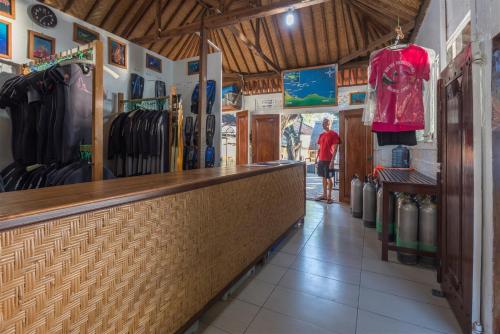 a man is standing at the counter of a store at Hotel Pondok Sari Beach & SPA Resort in Pemuteran