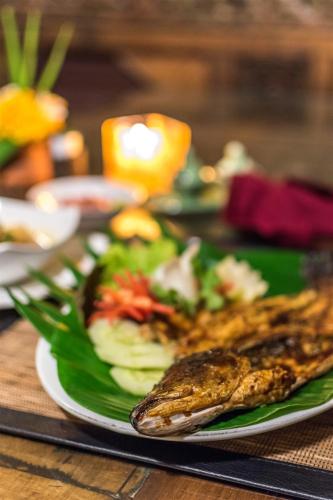 a plate of food on a table with a plate of food at Hotel Pondok Sari Beach & SPA Resort in Pemuteran