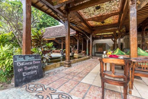 a restaurant with a sign in front of a building at Hotel Pondok Sari Beach & SPA Resort in Pemuteran
