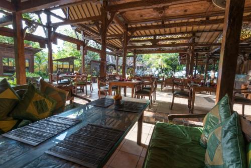 an empty restaurant with tables and chairs in the middle at Hotel Pondok Sari Beach & SPA Resort in Pemuteran