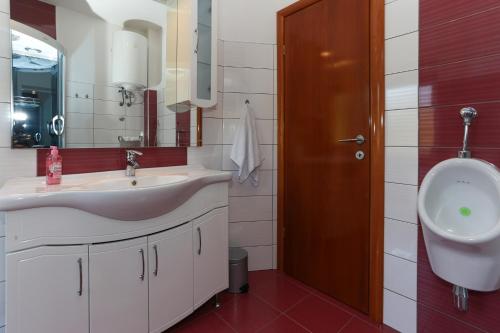 a bathroom with a sink and a urinal at Green Paradise Estate Trilj in Trilj