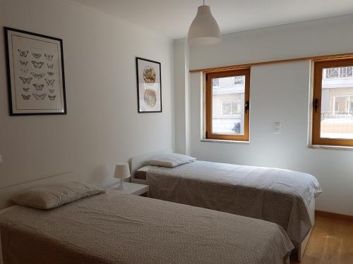 1 dormitorio con 2 camas y ventana en Quinta dos Lombos, en Carcavelos