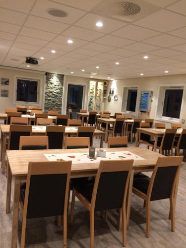 a dining room with wooden tables and chairs at Mjøsvang Kafe in Vang I Valdres