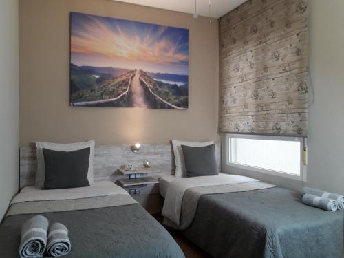 アリカンテにあるCasa Llorca Big Apt 3 Bedroom Garage AC WiFiのベッドルーム1室(ベッド2台付)が備わります。壁には絵画が飾られています。