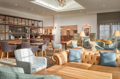 a hotel lobby with couches and tables and chairs at Forest Pines Hotel, Spa & Golf Resort in Scunthorpe