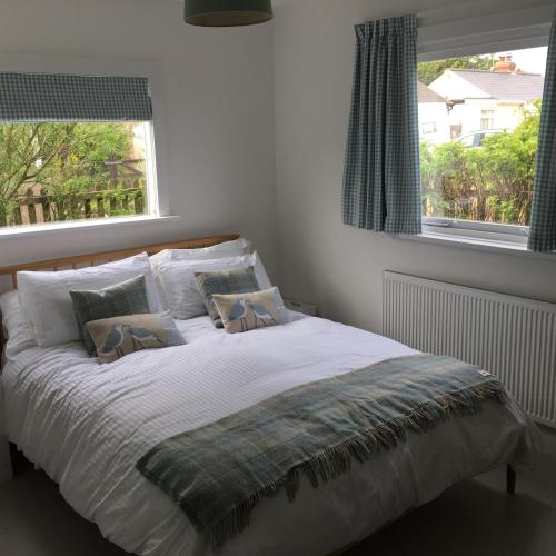 a bedroom with a large bed with two pillows at Owlers Retreat in Camber