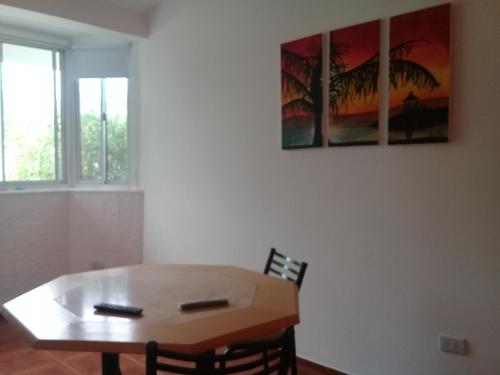 a dining room with a table and two paintings on the wall at La casita de Chany in Mina Clavero