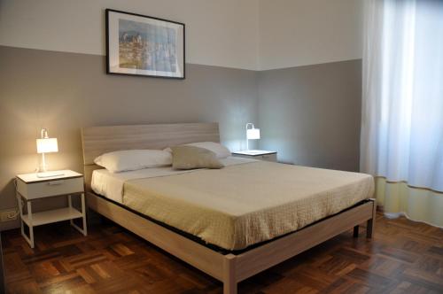 ein Schlafzimmer mit einem Bett mit zwei Tischen und zwei Lampen in der Unterkunft Rhome Away Trastevere - Domus in Rom