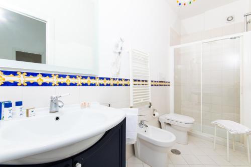 a white bathroom with a sink and a toilet at Residence Due Torri in Maiori