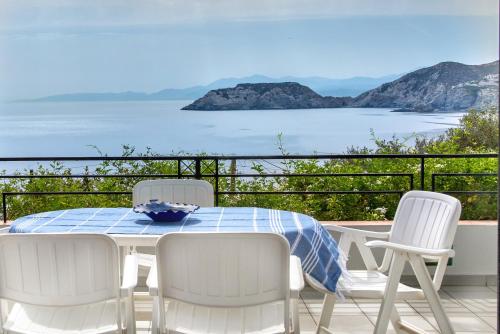 a table and chairs on a balcony with a view of the ocean at Eva Mare Hotel & Suites - Adults only in Agia Pelagia
