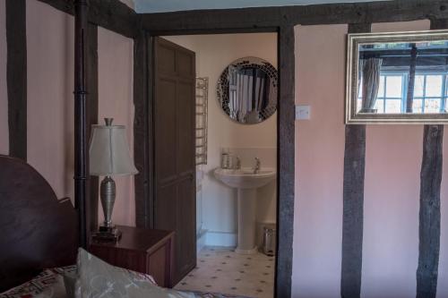uma casa de banho com um lavatório e um espelho em St Mary’s Bed & Breakfast em Bury Saint Edmunds