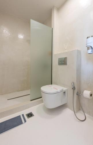 a white bathroom with a toilet and a shower at Eva Mare Hotel & Suites - Adults only in Agia Pelagia