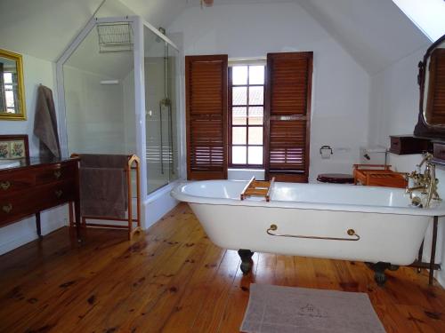 La grande salle de bains est pourvue d'une baignoire et d'un lavabo. dans l'établissement The Gables, à Hout Bay