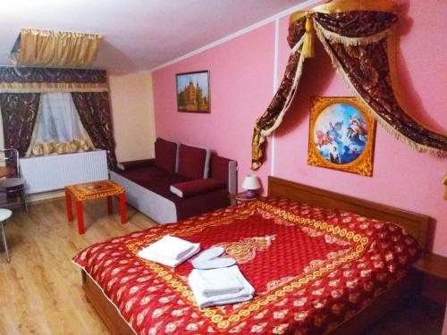 1 dormitorio con cama roja y sofá en Old Castle Hotel, en Leópolis