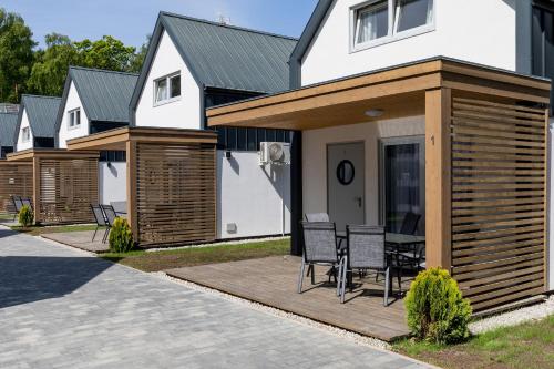 une maison dotée d'une terrasse en bois avec des chaises. dans l'établissement Kotwica-Pobierowo Bukowa 1, à Pobierowo