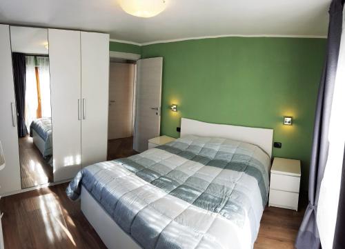 um quarto com uma cama e uma parede verde em Palmira Guest House em Aosta