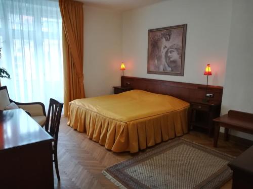 カルロヴィ・ヴァリにあるHalada house apartmentsのテーブル付きの部屋にベッド付きのベッドルームがあります。