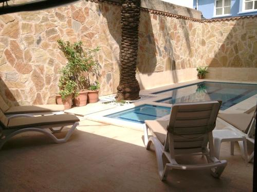 een patio met 2 stoelen en een zwembad bij Held Hotel in Antalya