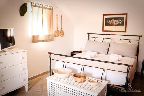 Villa Palmirotta Trulli Relais في كاستيلانا غروتي: غرفة نوم عليها سرير وسلاتين