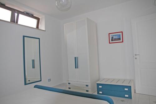 a white bathroom with a mirror and a blue rail at Corinto in Canneto
