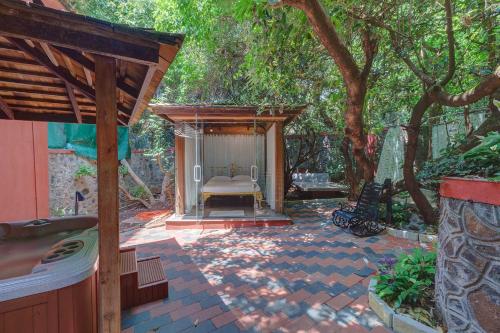 a patio with a bench under a tree at Ramsukh Resorts and Spa in Mahabaleshwar