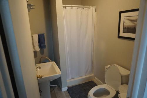 a bathroom with a white toilet and a sink at Charlevoix House in Charlevoix