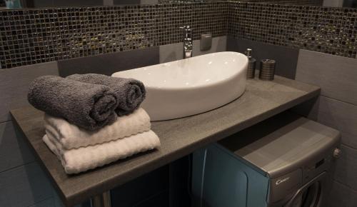 a bathroom with a sink and towels on a counter at Apartament Onyx in Poznań